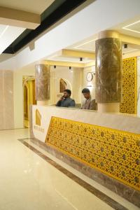two men standing at a counter in a mall at Hotel Bariz Perinthalmanna in Perintalmanna