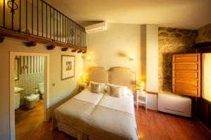 a bedroom with a bed in a room with a staircase at Hospedium Hotel Rural Ruta Imperial H-CC-00660 in Jarandilla de la Vera
