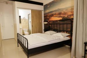 a bedroom with a bed with a painting on the wall at Motel Remo in Lovrin