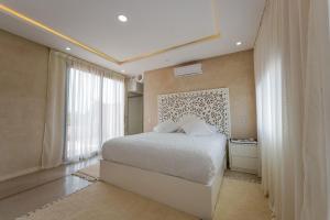 a bedroom with a bed and a large window at Dar El Gharrabia villa entièrement privatisée in Amezrou +49 photos