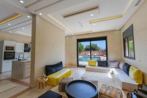 a living room with a couch and a table at Dar El Gharrabia villa entièrement privatisée in Amezrou