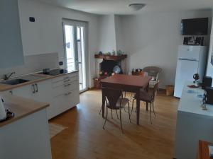 a kitchen with a table and chairs in a room at La Gabbianella - Locazione turistica in Marone