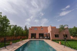 a house with a swimming pool in front of a building at Dar El Gharrabia villa entièrement privatisée in Amezrou