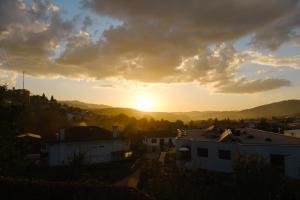 a sunset over a city with houses and mountains at Casa Horizontes de Arouca in Arouca