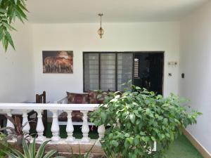 a porch of a house with a couch and some plants at EUNICE'S CLASSY DIANI STUDIO in Ukunda