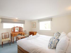 a bedroom with a bed and a desk and a mirror at Orchard Barn in Salcombe