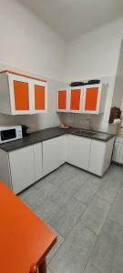 a kitchen with orange and white cabinets and a sink at Musica del Mare in Monterosso al Mare