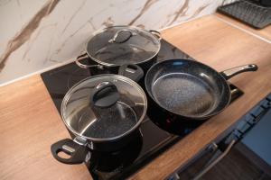 two pots and pans sitting on top of a stove at Sandy'sLuxuryApartment in Alexandroupoli