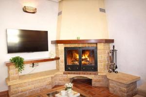 a living room with a fireplace with a flat screen tv at La Casona del Olivo - Pool, Patio, BBQ & Pet-Friendly in Torre-Pacheco