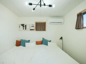 a bedroom with a large white bed in a room at Aso Grand View in Aso