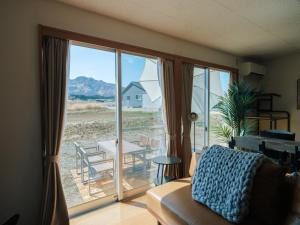 a living room with a large sliding glass door at Aso Grand View in Aso