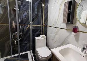 a bathroom with a shower and a toilet and a sink at Mumtoz East Hotel in Bukhara +28 photos