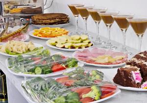 a table with plates of food and glasses of wine at Mumtoz East Hotel in Bukhara