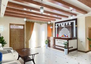 a living room with a couch and a tv at Mumtoz East Hotel in Bukhara