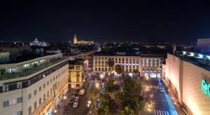 Blick auf eine Stadt in der Nacht mit Gebäuden in der Unterkunft Hotel Duquesa in Sevilla