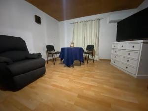 a living room with a table and chairs and a couch at Refugio Escondido in Isla de Maipo