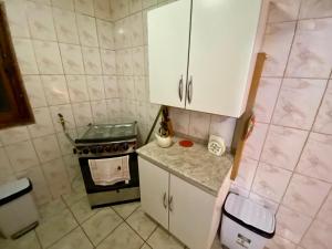 a small kitchen with a stove and white cabinets at Refugio Escondido in Isla de Maipo +17 photos