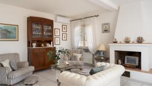 a living room with two chairs and a fireplace at VILLA PERELLE 8, Emma Villas in Rio nellʼElba