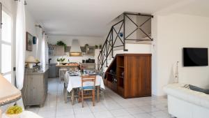 a kitchen and a dining room with a table and chairs at VILLA PERELLE 8, Emma Villas in Rio nellʼElba