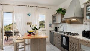 a kitchen with a counter and a table with fruit on it at VILLA PERELLE 8, Emma Villas in Rio nellʼElba