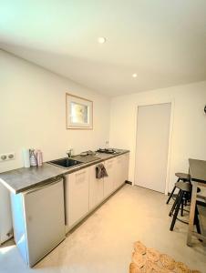 an empty kitchen with a sink and a table at Maisonnette des vignes in Albertville