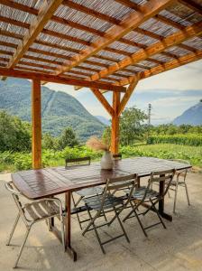 a wooden table and chairs under a wooden roof at Maisonnette des vignes in Albertville