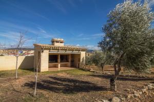 a small house with a tree in front of it at FINCA EL OLIVAR Casa Rural in Los Corrales