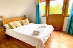 a bedroom with a bed with towels on it at Primrose Lodge with Hot Tub near Waterpark and Trails in Chudleigh