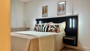 a bedroom with a large bed with a black headboard at Studio Red 14 - Sorocaba in Sorocaba +15 photos