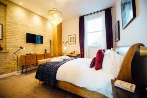 a hotel room with a bed and a tv at Banyers House in Royston