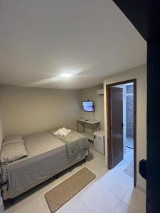 a bedroom with a bed and a tv on the wall at Zuppolini Garden apart-hotel in Bananeiras