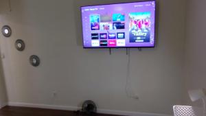 a flat screen tv hanging on a white wall at McAfee Private Room Shared Bathroom 1 in Decatur