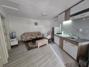 a kitchen and a living room with a couch at Rina House in Žabljak
