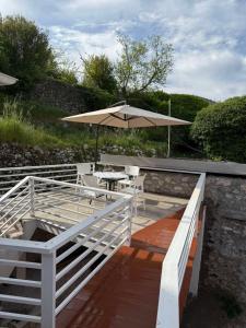 a wooden deck with a table and an umbrella at Rina House in Žabljak +1 photo