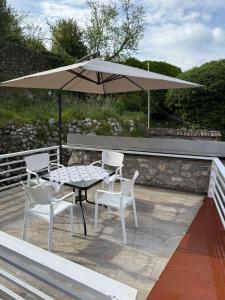 a table and chairs and an umbrella on a patio at Rina House in Žabljak
