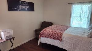 a bedroom with a bed and a chair and a window at McAfee Private Room Shared Bathroom 1 in Decatur