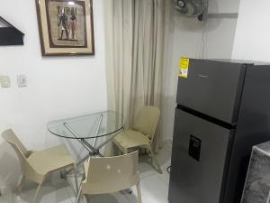 a kitchen with a glass table and a refrigerator at Estudio 1 Cerca PLAYA Y CENTRO HISTORICO in Santa Marta