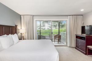 a hotel room with a large bed and a balcony at Rosario Resort in Eastsound
