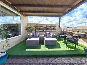 a patio with two couches and a table and chairs at Julina Boutique Living in Mosta
