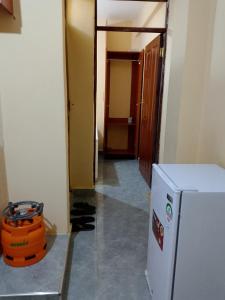 a hallway with a white refrigerator and a room at Mwembe Airbnbs in Kisii