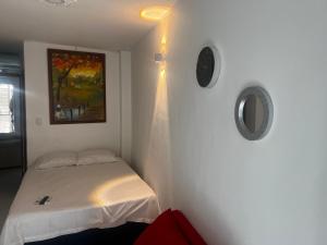 a small bedroom with a bed and a painting on the wall at Estudio 1 Cerca PLAYA Y CENTRO HISTORICO in Santa Marta