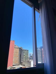 a window with a view of a city at Quarto Astral in Recife