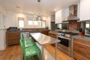 a kitchen with a table and some green chairs at The Modern Cottage in Bend