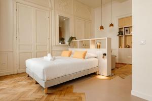 a bedroom with a large white bed with orange pillows at CENTRAL Hôtel La Rochelle Centre in La Rochelle
