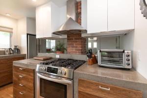 a kitchen with a stove and a microwave at The Modern Cottage in Bend