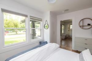 a white bedroom with a bed and a window at The Modern Cottage in Bend +18 photos