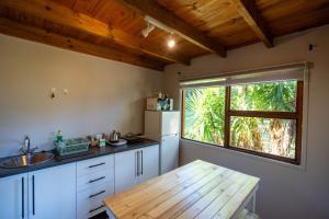 a kitchen with a wooden table and a window at A Stone's Throw in Grahamstown +70 photos