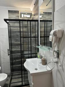 a white bathroom with a sink and a mirror at apartament gezuar in Golem