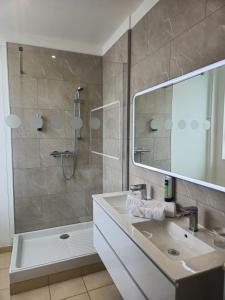a bathroom with a sink and a shower at Logis Loire Hotel - Les Cocottes Restaurant in Les Rosiers +24 photos