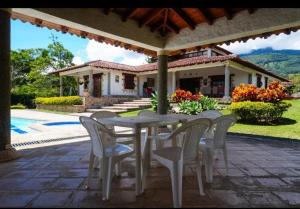 a table and chairs on a patio in front of a house at La Mona in Calima